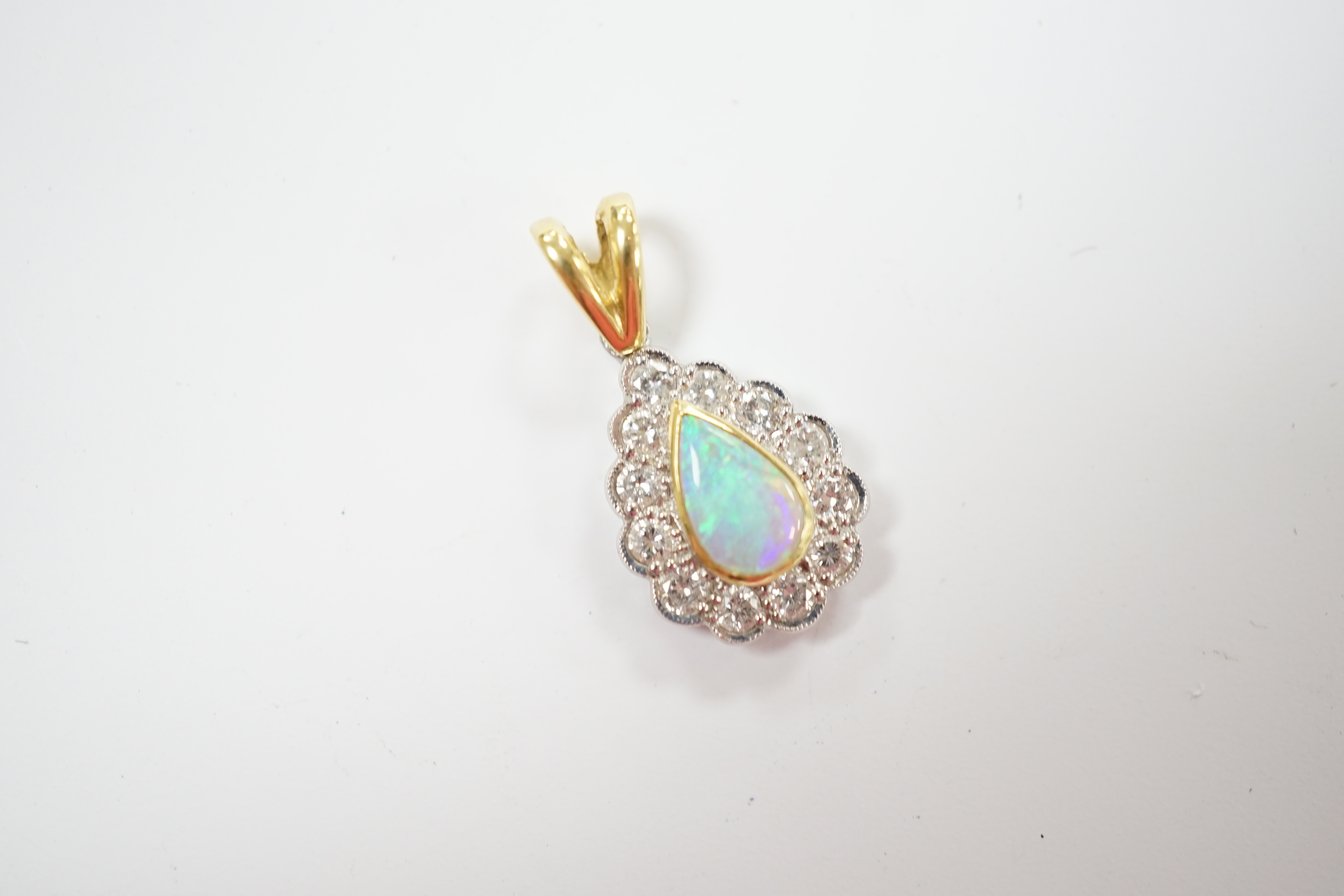 A modern 18ct gold, white opal and diamond set pear shaped cluster pendant, overall 23mm, gross weight 2.6 grams.